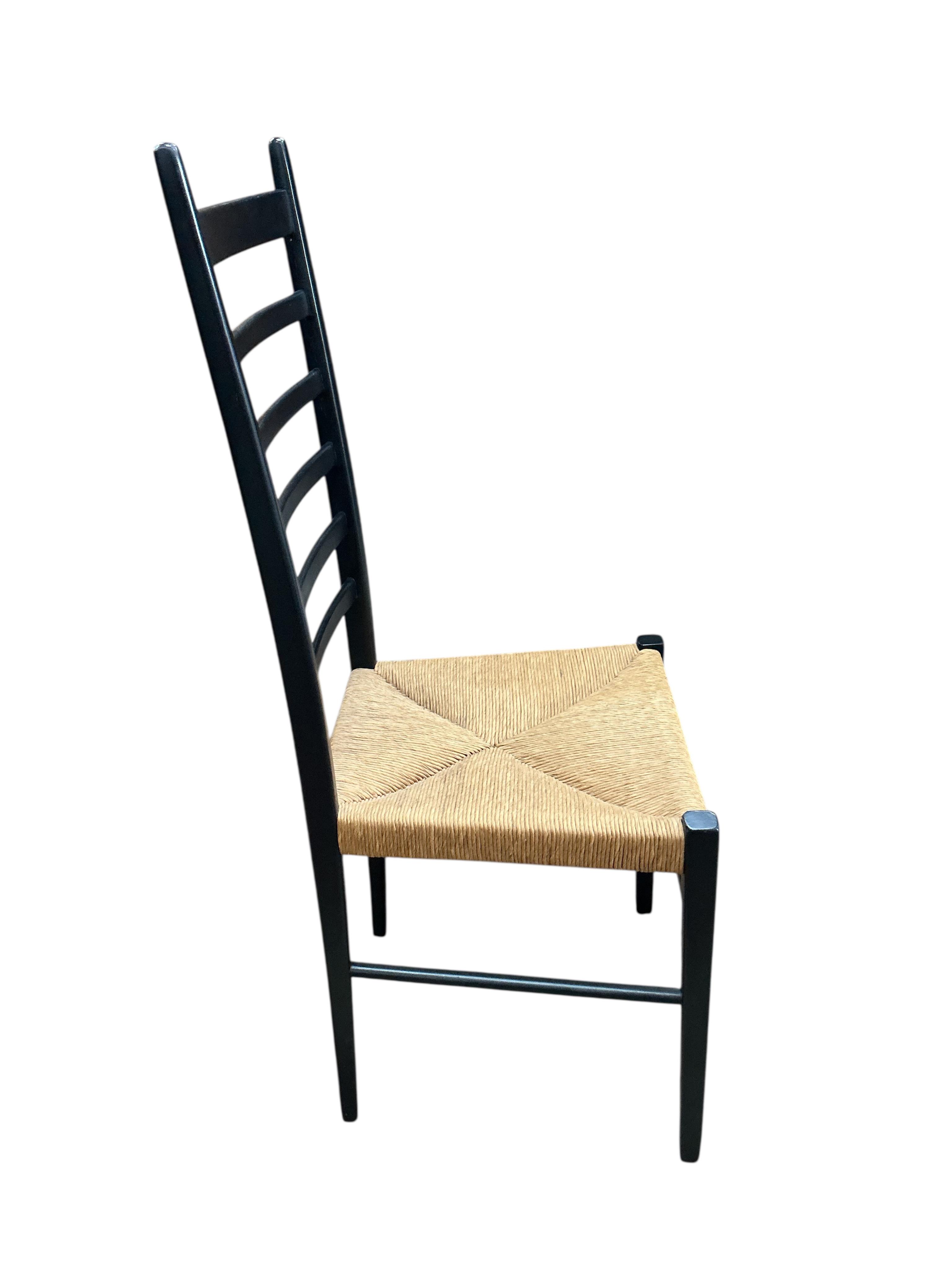 A set of four Gio Ponti ebonised ladderback rush seat dining chairs, width 40cm, depth 41cm, height 107cm